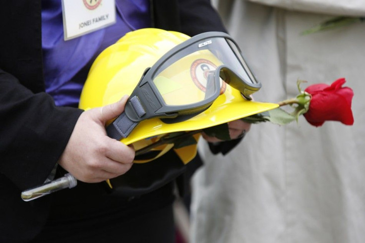 The helmet of a late BC Wildfire Management Branch Fire Warden is held by his daughter during the Canadian Fallen Firefighters memorial in Ottawa