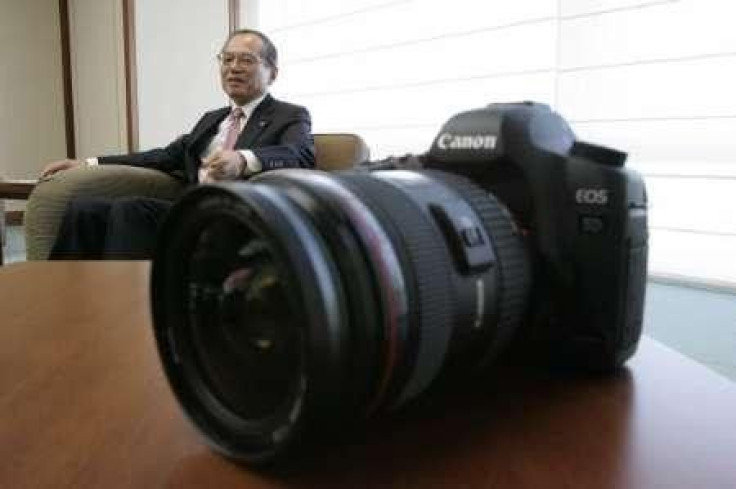 Canon Inc President Tsuneji Uchida speaks next to the latest Canon