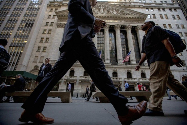 Morning commuters pass by the New York Stock Exchange September 15, 2014.