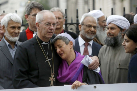The Archbishop of Canterbury, Justin Welby (2L), Senior Rabbi Laura Janner-Klausner (C), Imam Shaykh Ibrahim Mogra (2R) and Sayeeda Warsi (R) react together at the close of a vigil outside Westminster Abbey in central London September 3, 2014. Religious l