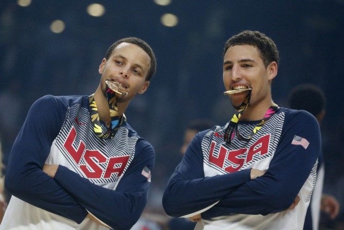 U.S. players Stephen Curry (L) and Klay Thompson bite their gold medals after winning their Basketball World Cup final game against Serbia in Madrid September 14, 2014.