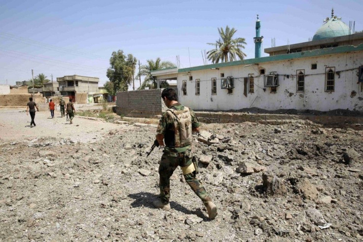 A Kurdish Peshmerga fighter walks past a mosque damaged by an airstrike in Suleiman Beg, after the town was retaken on Monday September 3, 2014. REUTERS/Ahmed Jadallah (IRAQ - Tags: CIVIL UNREST POLITICS)