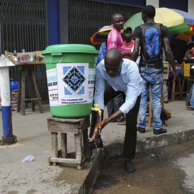 A man washes his hands as a preventive measure against the Ebola virus on a street in Monrovia, September 13, 2014. REUTERS/James Giahyue (LIBERIA - Tags: HEALTH SOCIETY)