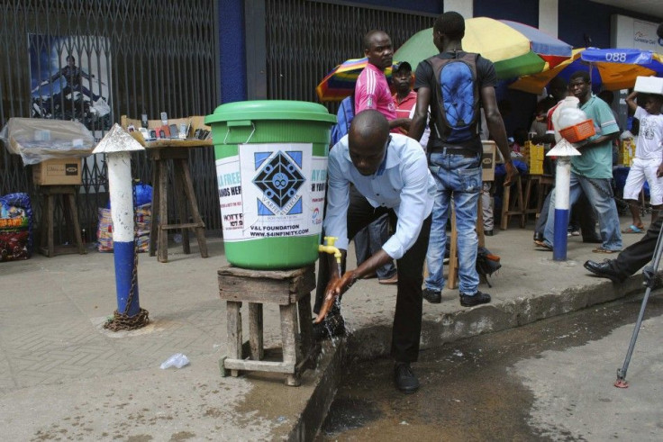 A man washes his hands as a preventive measure against the Ebola virus on a street in Monrovia, September 13, 2014. REUTERS/James Giahyue (LIBERIA - Tags: HEALTH SOCIETY)