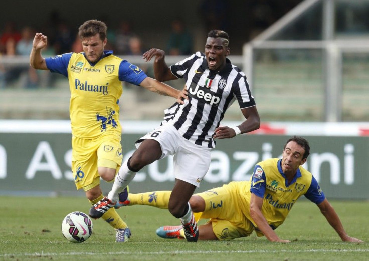 Juventus&#039; Paul Pogba (C) fights for the ball with Chievo Verona&#039;s Perparim Hetemaj (L) and Dario Dainelli during their Italian Serie A soccer match at the Bentegodi stadium in Verona August 30, 2014.