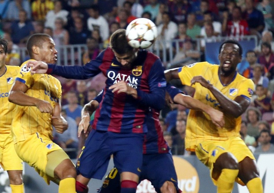 Barcelonas Gerard Pique C heads the ball to score a goal against Apoel Nicosias player Joao Guilherme L and Vinicius R during their Champions league soccer match at Camp Nou stadium in Barcelona September 17, 2014. REUTERSAlbert Gea 