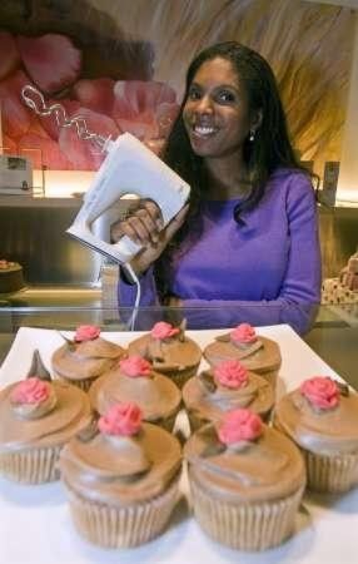 London-born former model Josephine Scorer poses near a tray of cappuccino cupcakes at her pastry shop
