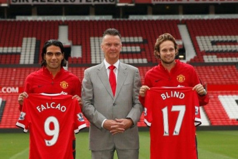 New Manchester United signings Radamel Falcao (L) and Daley Blind (R) pose with manager Louis Van Gaal during a photocall at Old Trafford in Manchester, northern England September 11, 2014.