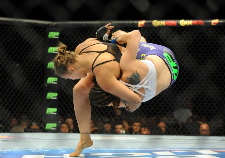 Jul 5, 2014; Las Vegas, NV, USA; Ronda Rousey (red gloves) takes down Alexis Davis (blue gloves) during the first round of a bantamweight fight at Mandalay Bay Events Center.