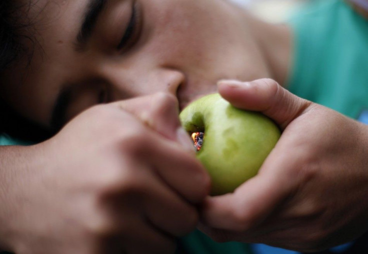 A man smokes marijuana using an apple adapted with a pipe during a demonstration calling for the legalisation of the drug in Guatemala City November 24, 2012.