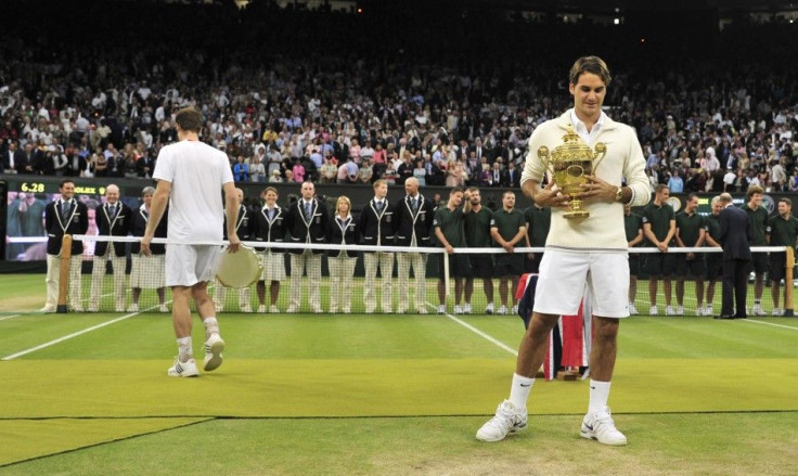 Roger Federer of Switzerland holds the winners trophy after defeating Andy Murray of Britain (L) in their men&#039;s singles final tennis match at the Wimbledon Tennis Championships in London July 8, 2012.