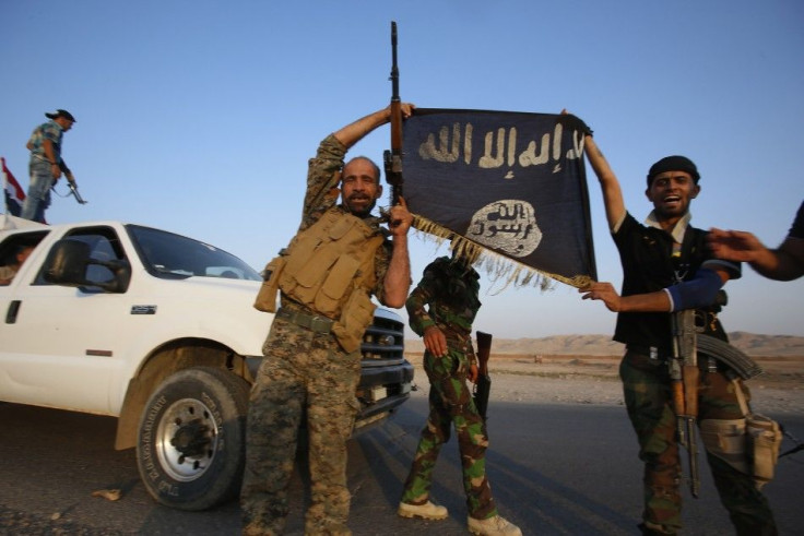 Iraqi Shiite militia fighters hold the Islamic State flag as they celebrate after breaking the siege of Amerli by Islamic State militants, September 1, 2014. Picture taken on September 1, 2014. REUTERS/Youssef Boudlal (IRAQ - Tags: CIVIL UNREST POLITICS M