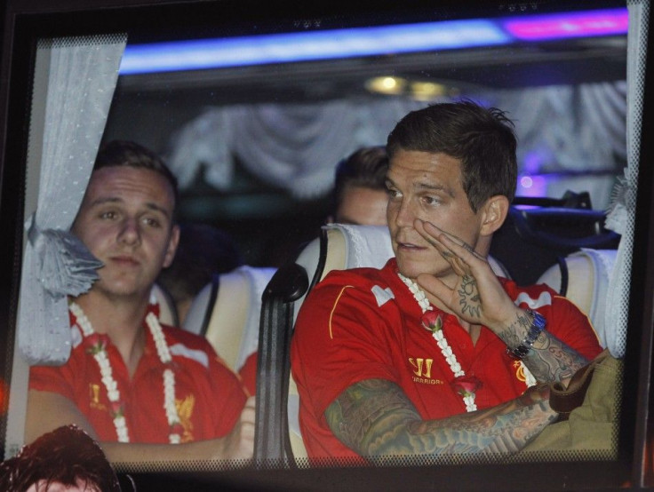 Liverpool's Daniel Agger waves to fans as his team arrives at Don Muang International Airport, ahead of Sunday's soccer friendly against Thailand's national team as part of the team's Asia tour, in Bangkok July 25, 2013.