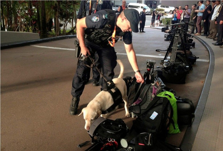 Australian Federal Police (AFP) officers use a dog to inspect equipment