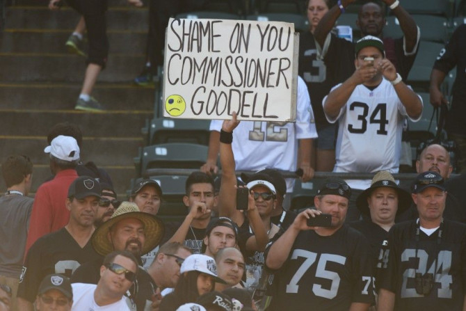 An Oakland Raiders fan holds a sign for NFL commissioner Roger Goodell after the game