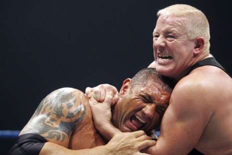 Batista &quot;The Animal&quot; (L) grimaces while wrestling with Dave Finlay during the &quot;Pressing catch: SmackDown&quot; World Wrestling Entertainment show in Madrid December 6, 2006.