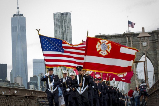 Members of the New York City Fire Department carry flags across the Brooklyn Bridge after attending memorial observances on the 13th anniversary of the 911 attacks at the site of the World Trade Center in New York, September 11, 2014. Politicians, dignita
