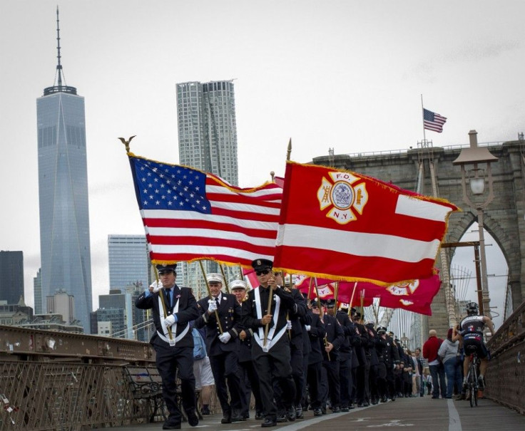 Members of the New York City Fire Department carry flags across the Brooklyn Bridge after attending memorial observances on the 13th anniversary of the 911 attacks at the site of the World Trade Center in New York, September 11, 2014. Politicians, dignita