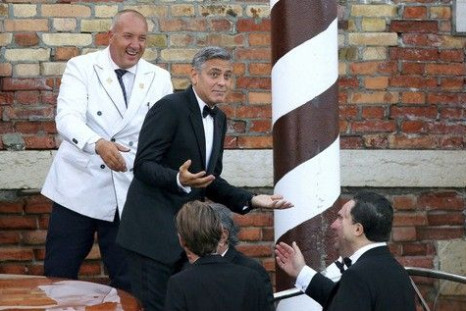 U.S. actor George Clooney  (top 2nd L) gestures as he leaves by taxi boat to travel to the venue of a gala dinner ahead of his official wedding ceremony in Venice September 27, 2014. 
