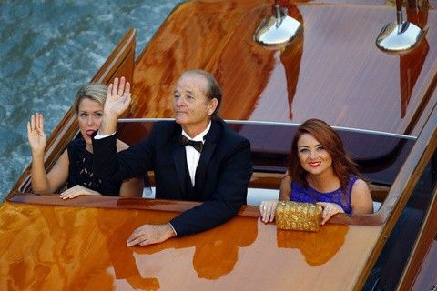 U.S. actor Bill Murray waves while travelling in a taxi boat in the Grand Canal in Venice, ahead of a gala dinner September 27, 2014.