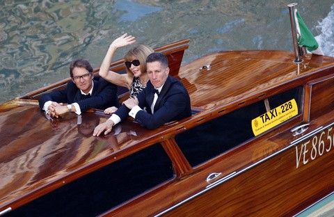 U.S. Vogue editor Anna Wintour waves from a taxi boat in the Grand Canal in Venice, ahead of a gala dinner September 27, 2014. 