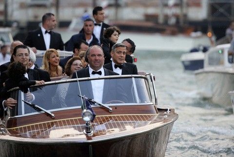 U.S. actor George Clooney C travels in a taxi boat on the Grand Canal in Venice to the venue of a gala dinner ahead of his official wedding ceremony to fiancee Amal Alamuddin September 27, 2014.