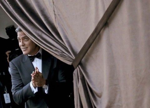 U.S. actor George Clooney gestures as he arrives by taxi boat to the venue of a gala dinner ahead of his official wedding ceremony in Venice September 27, 2014.