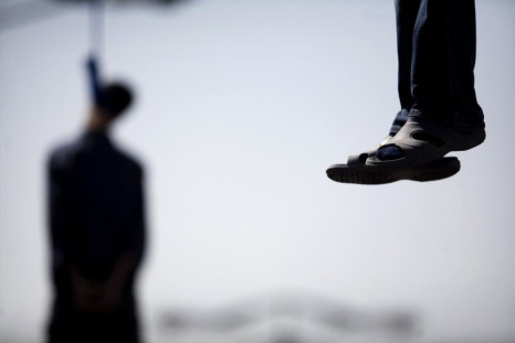 Majid Kavousifar and Hossein Kavousifar, his nephew, hang from the cable of a crane