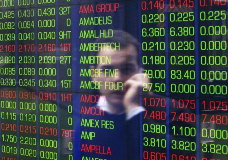 An office worker talks on his phone as he looks the stock board at the Australian Securities Exchange (ASX) building in central Sydney June 15, 2012. Asian shares edged up on Friday, and the euro held most of the previous session's gains, as nervous inves