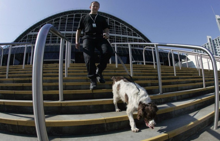 A police dog handler and his sniffer dog walk away from the GMEX (Greater Manchester Exhibition centre) in Manchester, northern England September 21, 2006, The British Labour Party's annual conference runs at the GMEX from September 23-28, 2006.