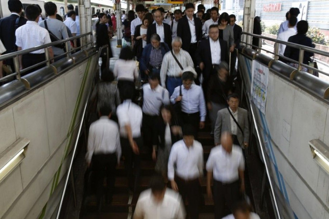 People walk down stairs in a train station in Tokyo's business district September 30, 2014. Japanese big manufacturers' confidence improved slightly in the three months to September, a closely watched central bank survey showed, but service-sector sentime