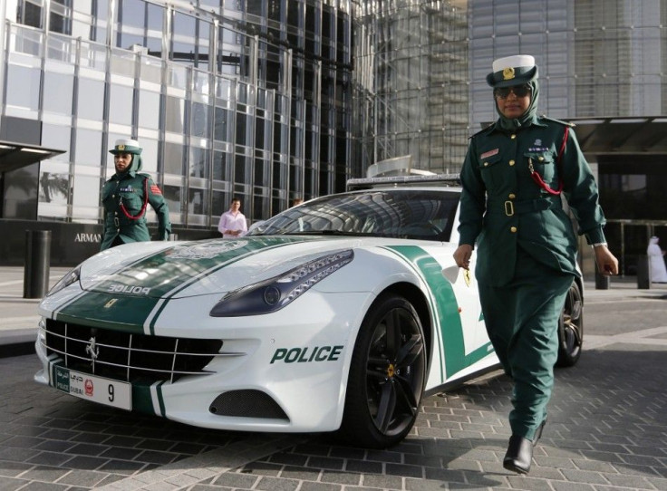 Police officer Badrya Salem AlSowaidi walks near a Ferrari police car ahead of a patrol in Dubai June 4, 2013. The Dubai Police fleet of cars includes Aston Martin, Bentley Continental GT Coupe, Ferrari, and a recently added Bugatti Veyron.