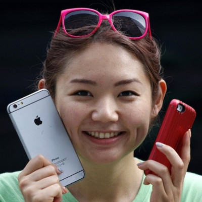 A Woman Holds A Mock iPhone 6 Plus (L) And An iPhone 5s.