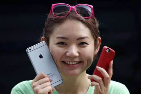 A Woman Holds A Mock iPhone 6 Plus (L) And An iPhone 5s.