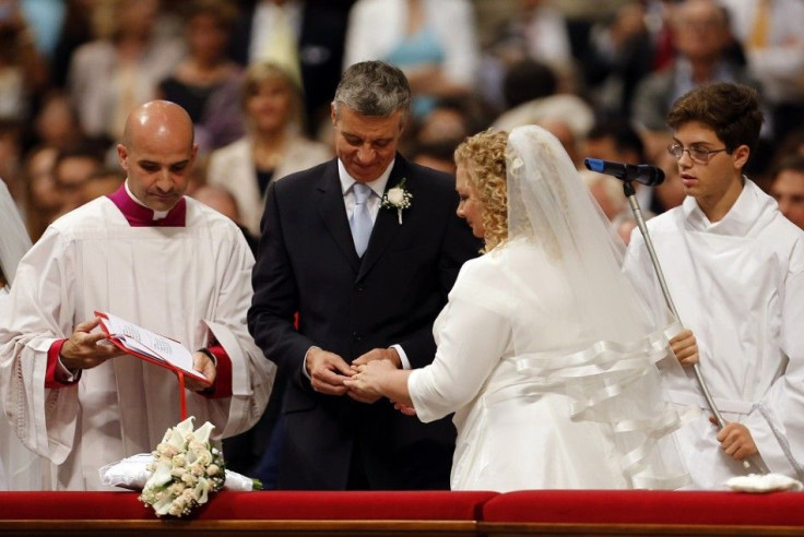 A groom exchanges rings with his bride during their wedding mass officiated by Pope Francis in St.Peter's Basilica at the Vatican, September 14, 2014.