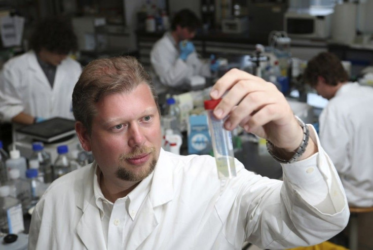 Belgian researcher Pierre Sonveaux poses with a sample of protein in his laboratory at the University of Louvain's Institute of Experimental and Clinical Research in Brussels July 31, 2014. According to the institute, the researcher has reached a breakthr