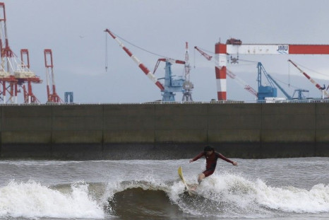 A surfer rides a wave as Typhoon Phanfone passes the area, at a beach in Tsu, Mie prefecture, October 6, 2014. Hundreds of flights were cancelled and thousands of people advised to evacuate as a powerful typhoon lashed Japan on Monday with heavy rains and