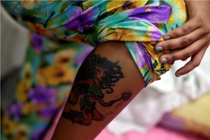 Jessica, 16, who was arrested by the police during a raid at a sex club, shows her tattoo