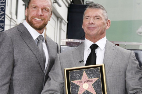Chairman Of World Wrestling Entertainment (WWE) Inc. Vince McMahon (R) Holds A Plaque