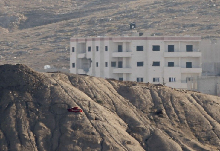 A black flag belonging to the Islamic State is seen near the Syrian town of Kobani, as pictured from the Turkish-Syrian border near the southeastern town of Suruc in Sanliurfa province, October 6, 2014. 