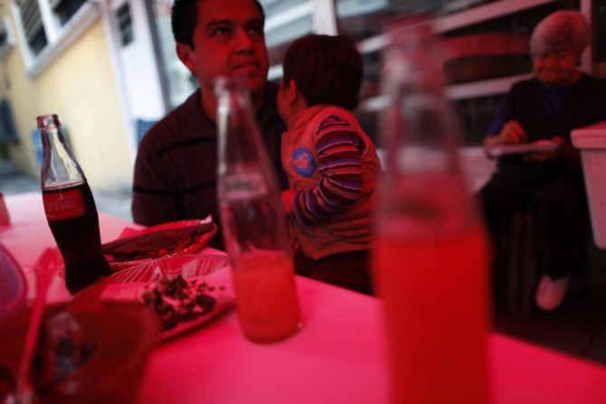 A man and a child eat next to bottled drinks at a food stand in Mexico City September 10, 2013.