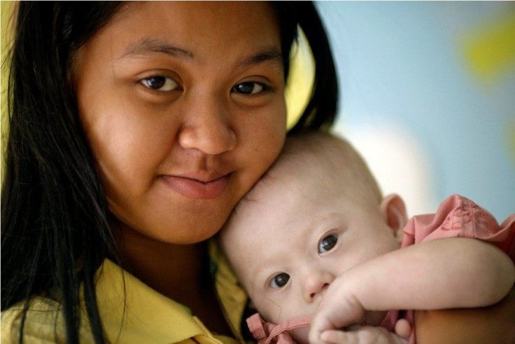 Gammy, a baby born with Down's Syndrome, is held by his surrogate mother