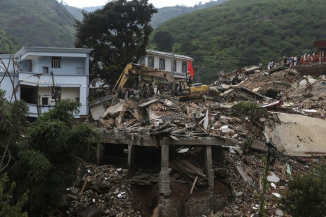 An excavator works on debris of houses to search for bodies of victims at the quake zone in Ludian county, Zhaotong, Yunnan province, August 5, 2014. An earthquake in China on the weekend triggered landslides that have blocked rivers and created rapidly g