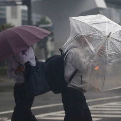 Passers-by with umbrellas struggle against strong winds and heavy rain caused by Typhoon Phanfone, in Tokyo October 6, 2014. Hundreds of flights were canceled and thousands of people advised to evacuate as a powerful typhoon lashed Japan on Monday with he