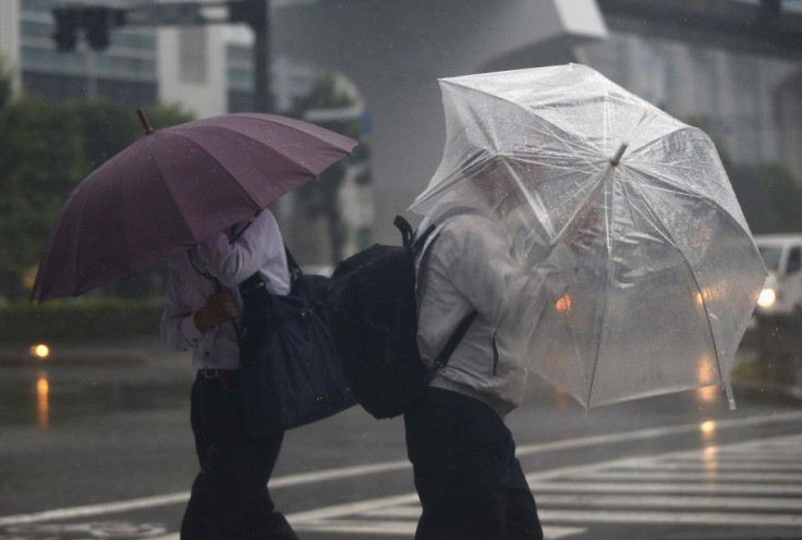 Passers-by with umbrellas struggle against strong winds and heavy rain caused by Typhoon Phanfone, in Tokyo October 6, 2014. Hundreds of flights were canceled and thousands of people advised to evacuate as a powerful typhoon lashed Japan on Monday with he