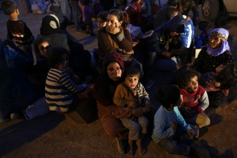 Syrian Kurdish refugees wait for transportation after crossing into Turkey, near the southeastern Turkish town of Suruc in Sanliurfa province September 30, 2014. Tens of thousands more Syrians could be forced to flee their war-torn homeland if Islamic Sta