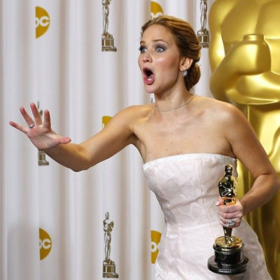 Jennifer Lawrence, best actress winner for her role in &quot;Silver Linings Playbook,&quot; reacts after photographers made a picture of her making an obscene gesture as she took the stage in the photo room with her Oscar at the 85th Academy Awards in Hol