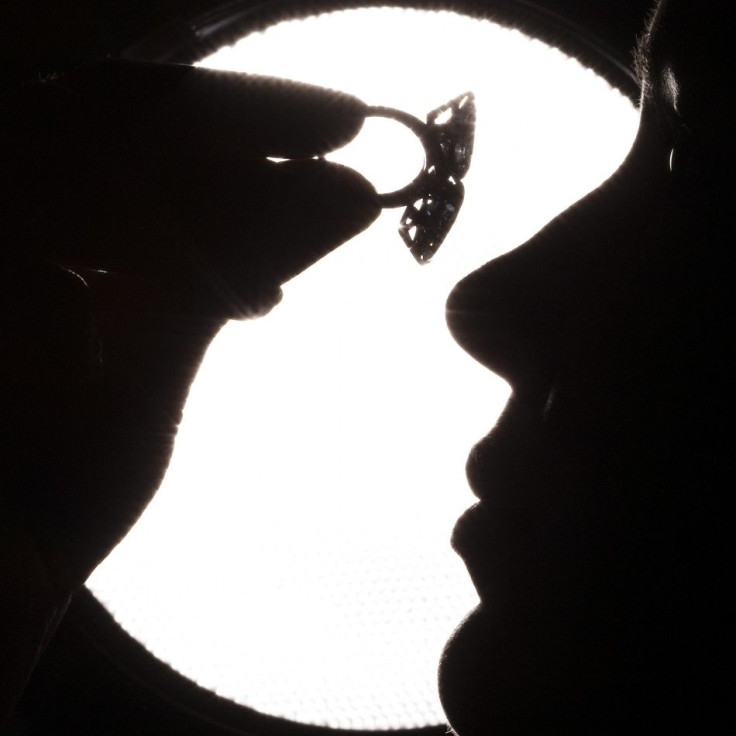 A model displays a ring made of a pear-shaped vivid blue diamond