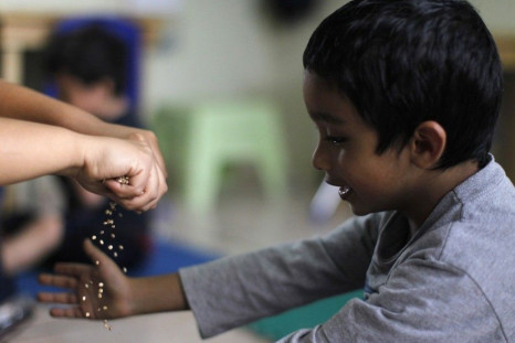 A boy plays with seeds during therapy at the therapy and development centre for autistic kids in the Asociacion Guatemalteca por el Autismo, or Guatemalan Association for Autism, building in Guatemala City March 13, 2014. Nine children, from 6-14 years ol