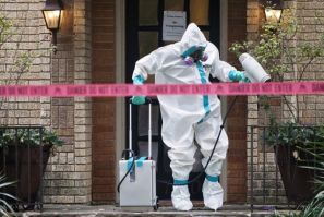 A member of the CG Environmental HazMat team disinfects the entrance to the residence of a health worker at the Texas Health Presbyterian Hospital who has contracted Ebola in Dallas, Texas, October 12, 2014. 